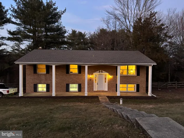 a view of a brick house with large windows and a yard
