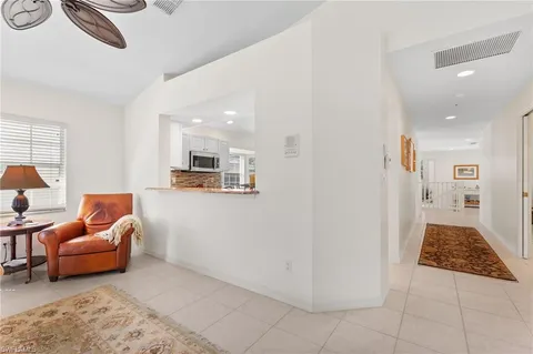 a living room with furniture a flat screen tv and a floor to ceiling window