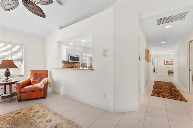 a living room with furniture a flat screen tv and a floor to ceiling window