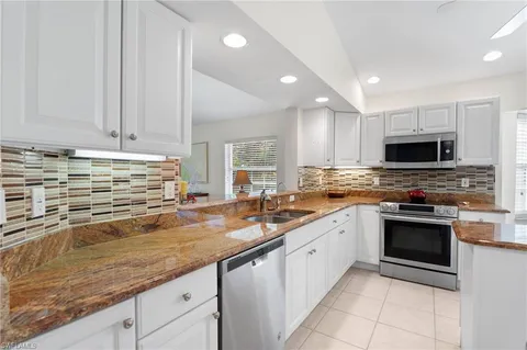 a kitchen with granite countertop a stove oven and sink
