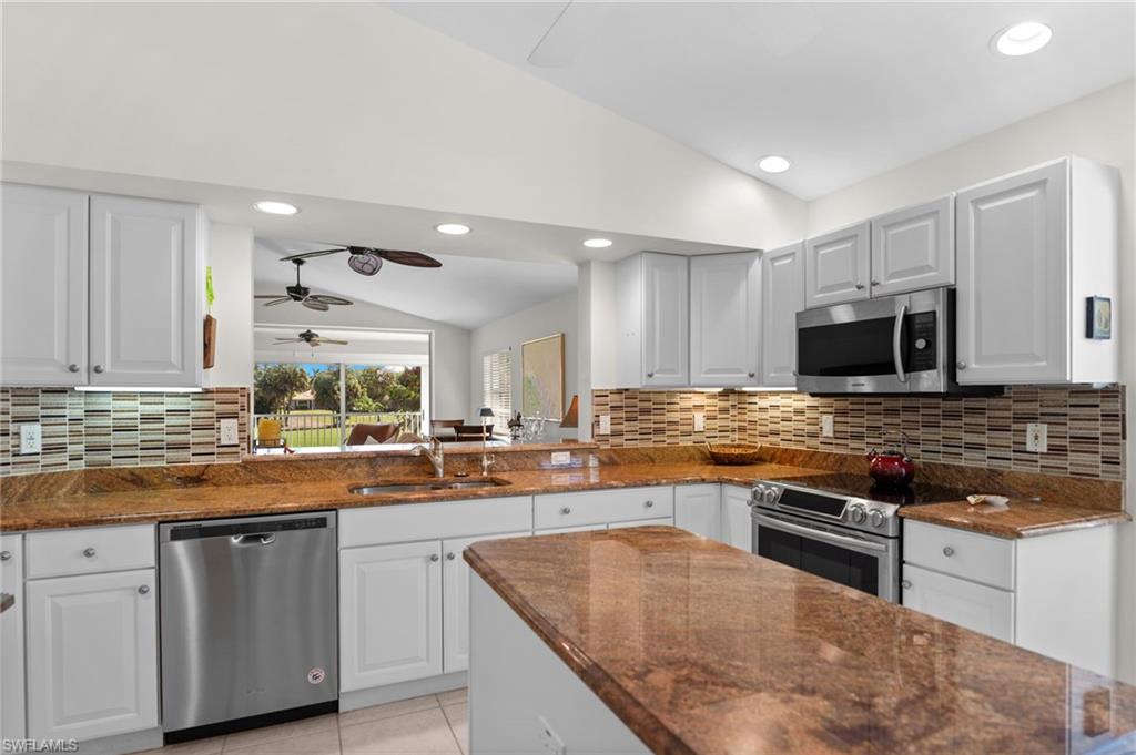 8500 Mystic Greens Way, Unit 506 Naples, FL 34113 - Photo 23 of 48 a kitchen with stainless steel appliances granite countertop a stove top oven a sink and dishwasher