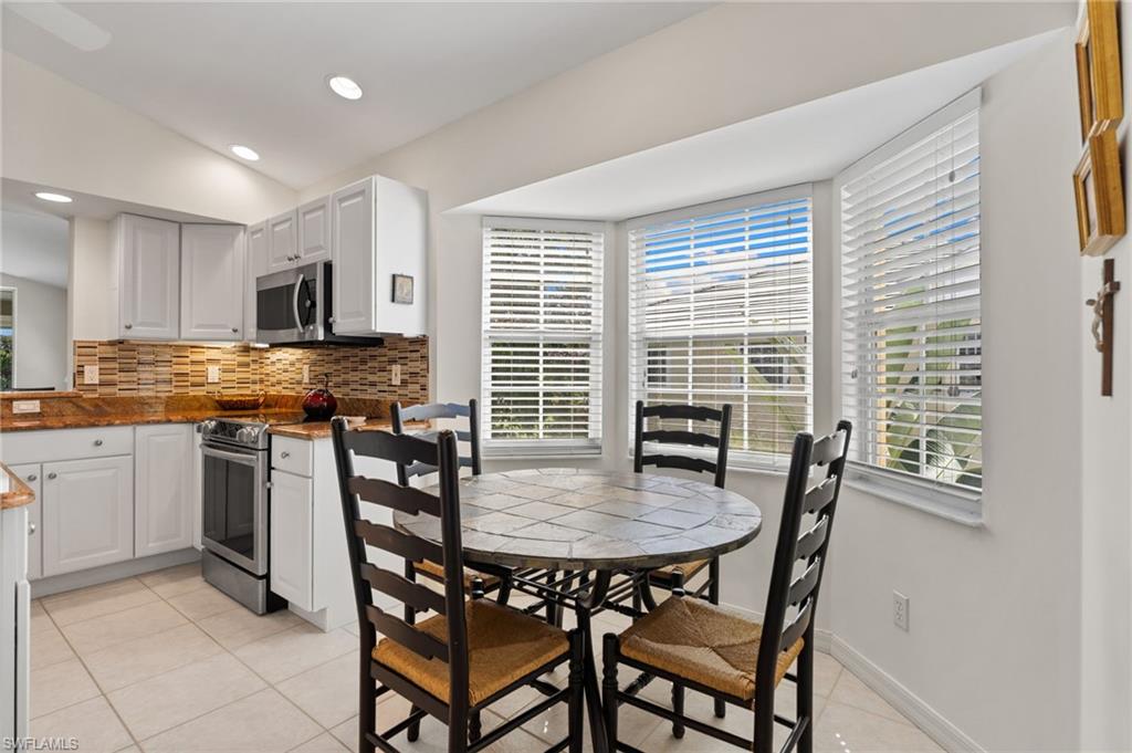 8500 Mystic Greens Way, Unit 506 Naples, FL 34113 - Photo 26 of 48 a kitchen with a dining table chairs and refrigerator