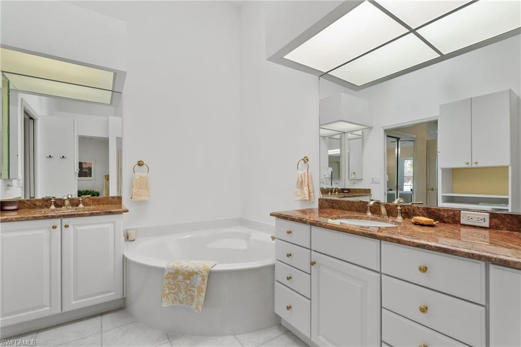 8500 Mystic Greens Way, Unit 506 Naples, FL 34113 - Photo 30 of 48 a spacious bathroom with a granite countertop tub sink and mirror