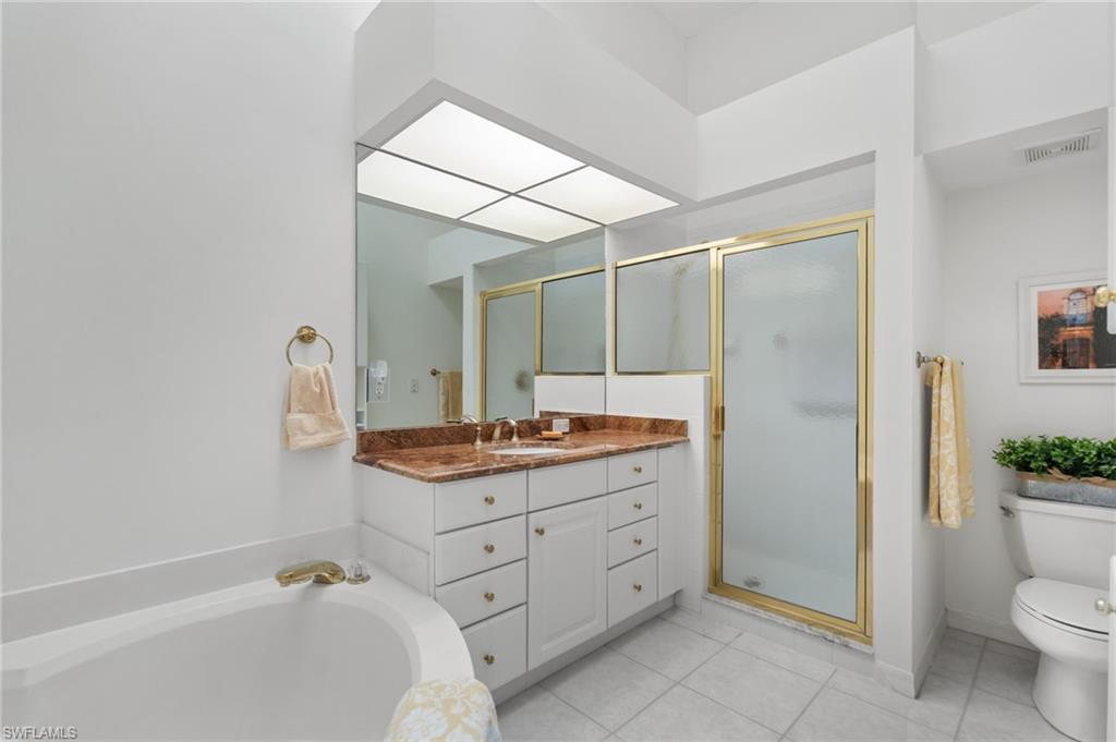 8500 Mystic Greens Way, Unit 506 Naples, FL 34113 - Photo 31 of 48 a bathroom with a granite countertop sink a toilet a mirror and shower