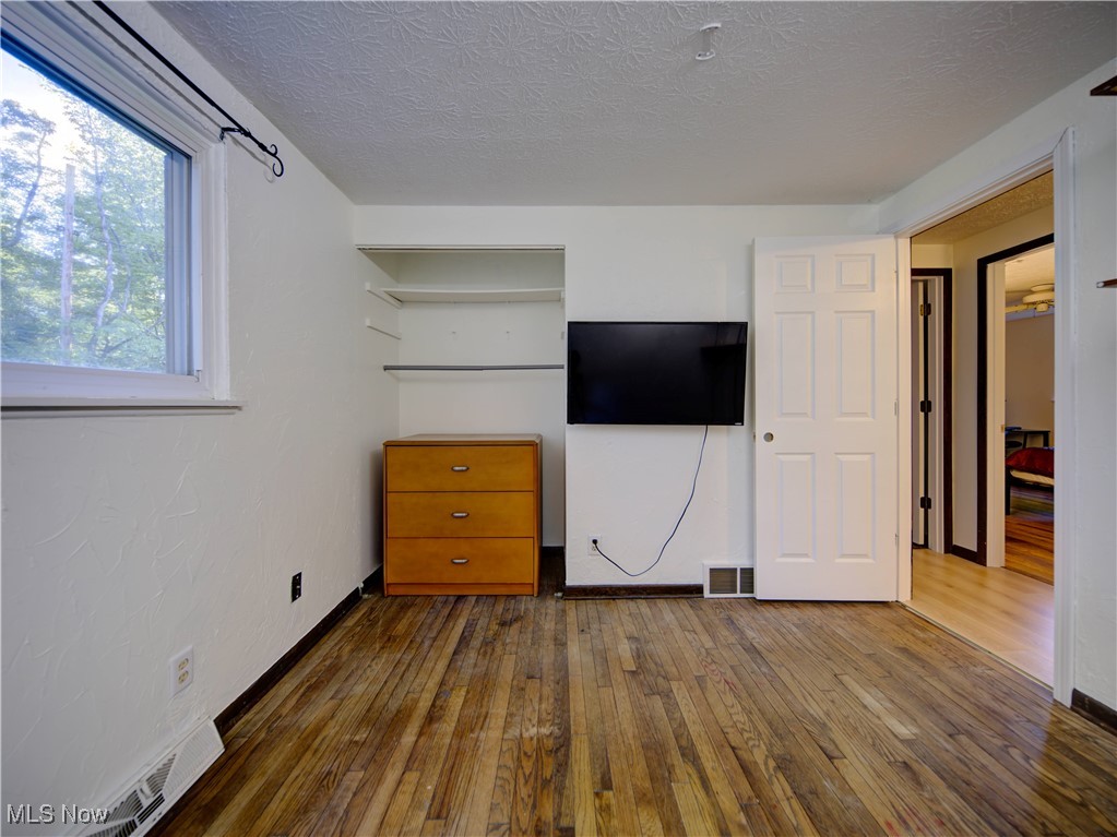 8075 Mulberry Road Chesterland, OH 44026 - Photo 25 of 38 Unfurnished bedroom with dark wood-style flooring and a textured ceiling