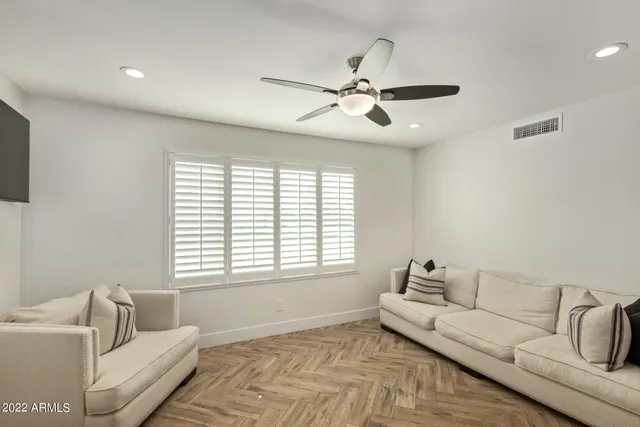 a living room with furniture a rug and white walls