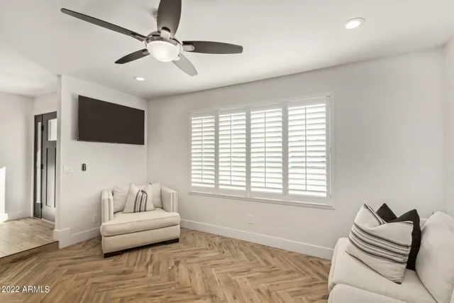 a large bedroom with a bed and wooden floor