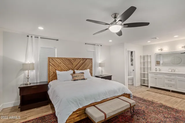 a bedroom with a bed mirror and a window