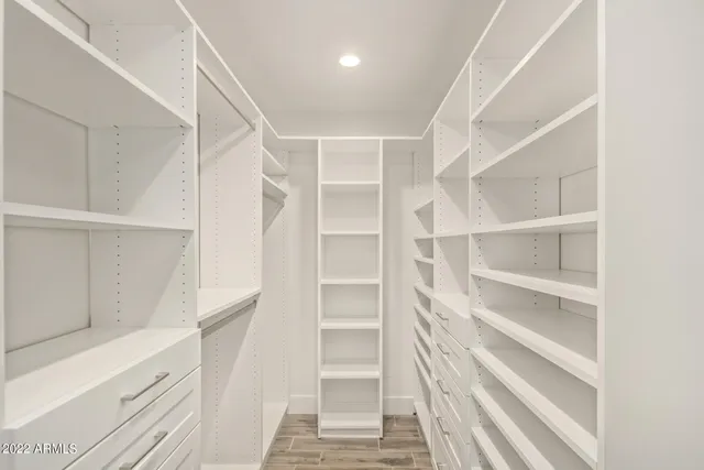 a view of walk in closet with empty racks