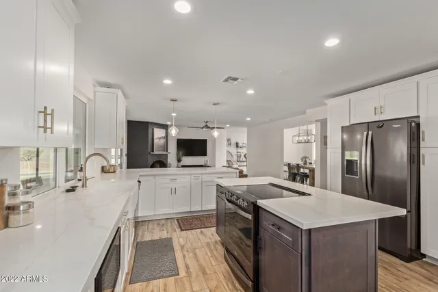 a large kitchen with a center island and stainless steel appliances