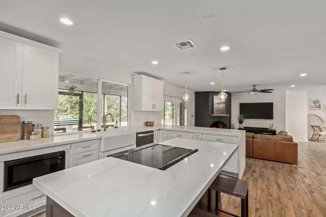 a large kitchen with sink a counter top space appliances and a window