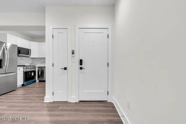 a view of a kitchen with wooden floor and electronic appliances