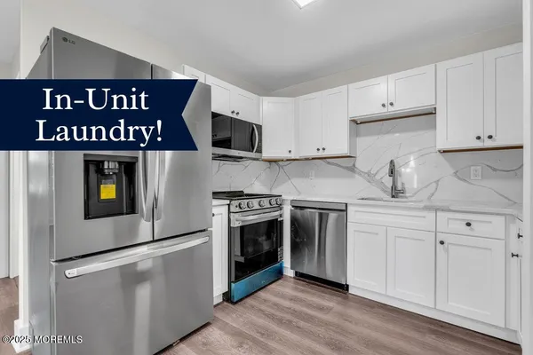 a kitchen with stainless steel appliances granite countertop a stove a sink and white cabinets