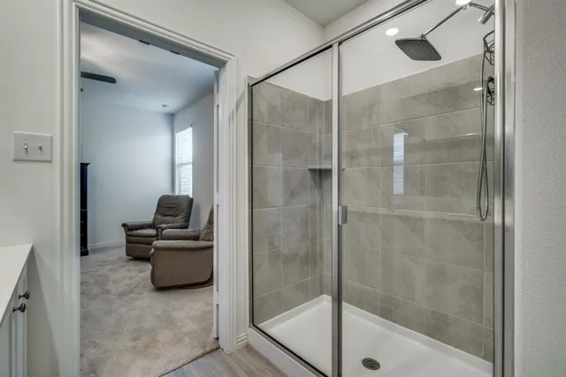 a bathroom with a sink double vanity granite tub shower and a mirror