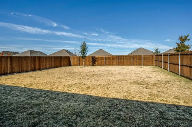 a view of a chairs and table in the backyard