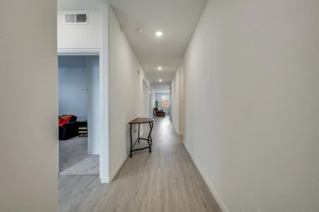 a view of a hallway with wooden floor and closet