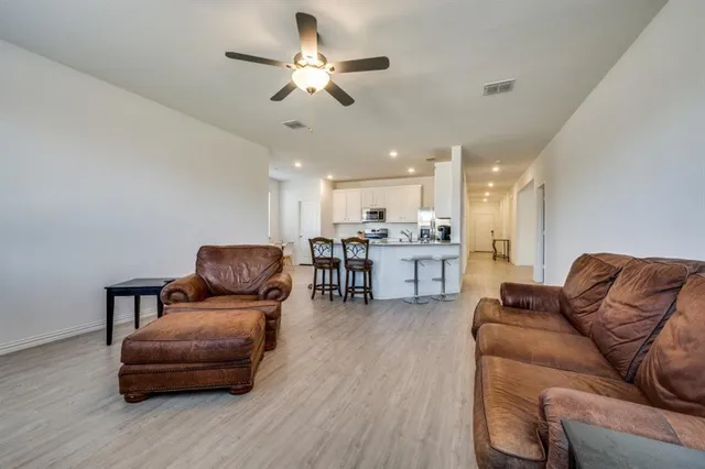 a living room with furniture and kitchen view