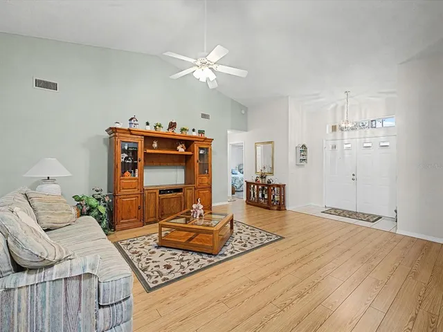 a dining room with furniture a chandelier and wooden floor