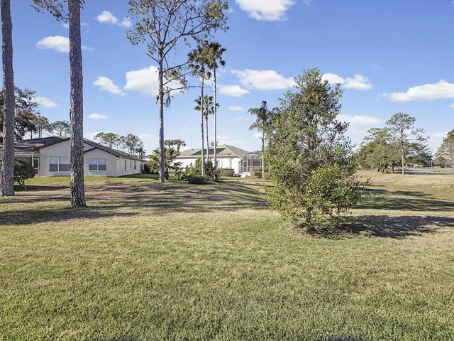 a view of a house with swimming pool next to a yard