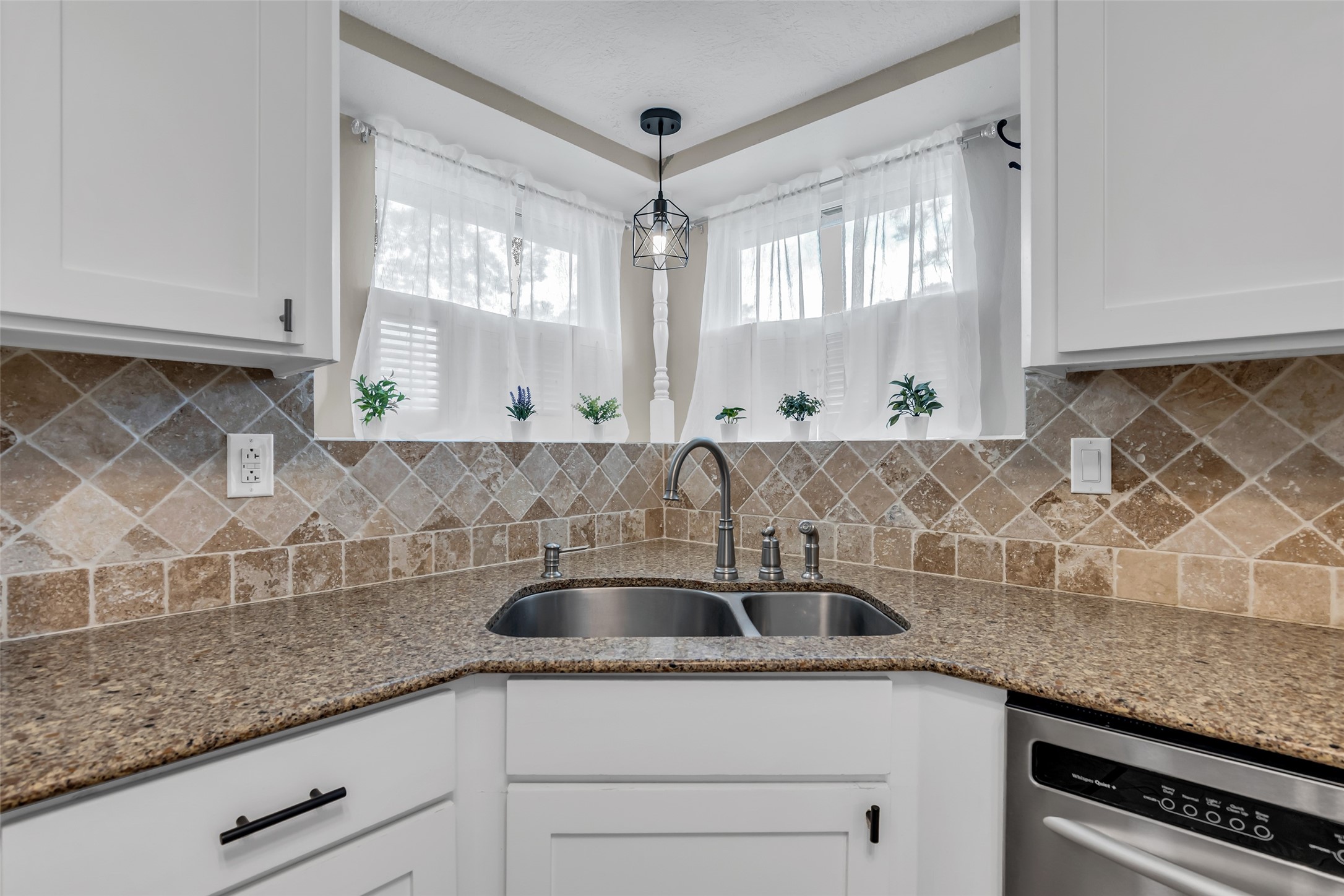 22502 Fields Lane Spring, TX 77389 - Photo 16 of 39 This kitchen features elegant granite countertops, a dual-basin stainless steel sink, and a stylish tile backsplash. Natural light filters through sheer curtains, creating a bright and inviting atmosphere.