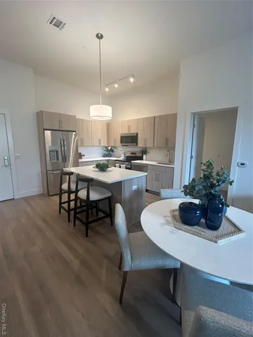 a kitchen with a dining table chairs and refrigerator
