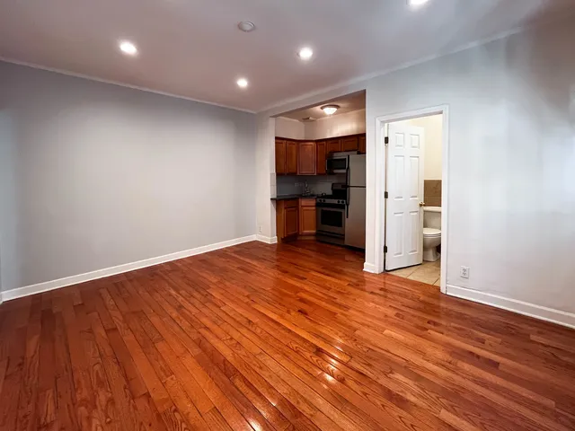 wooden floor in an empty room with a kitchen