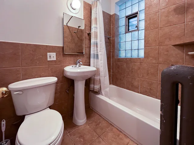 a white toilet sitting next to a bathroom sink and tub