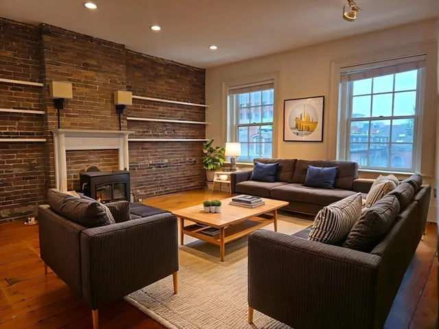 a living room with fireplace furniture and a window