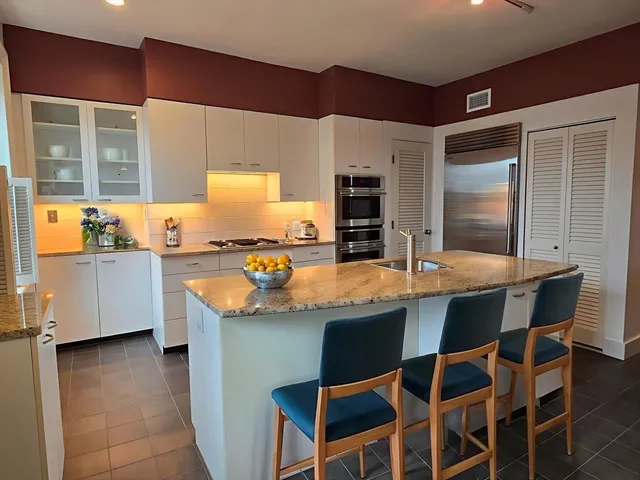 a kitchen with granite countertop a sink and a stove