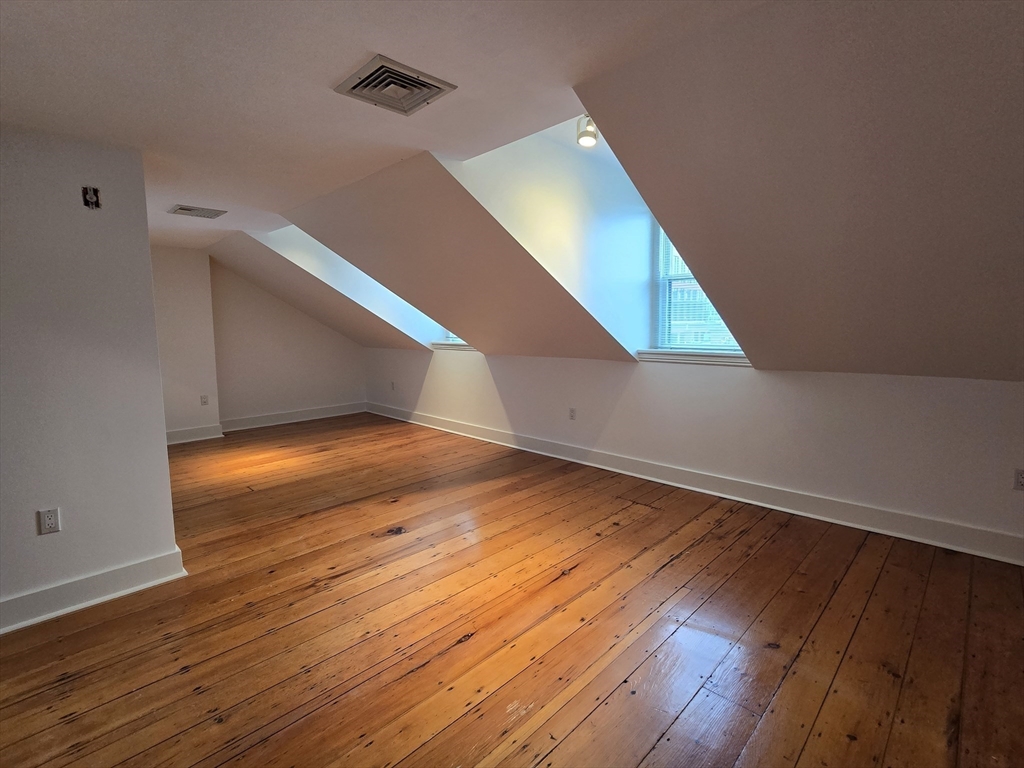 61 Otis Street, Unit 3 Cambridge, MA 02141 - Photo 9 of 18 a view of an empty room with wooden floor