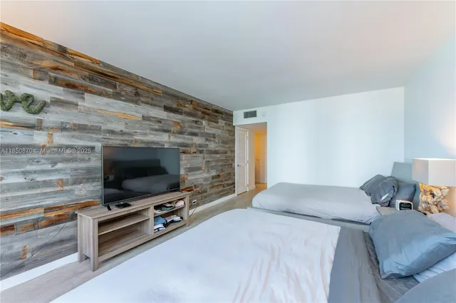 a bedroom with a bed and a flat screen tv