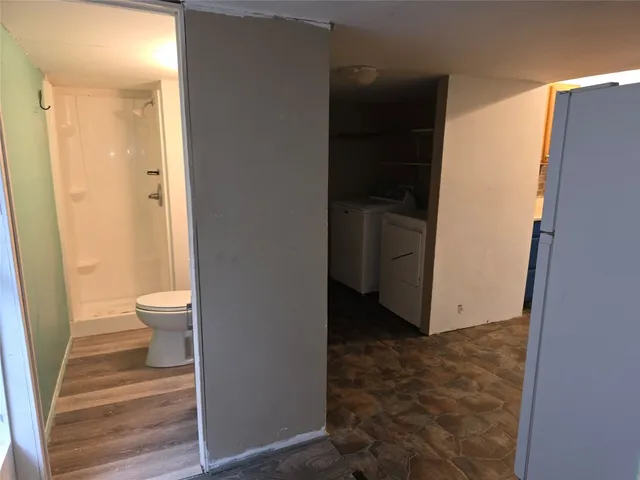 a bathroom with a granite countertop toilet and a shower