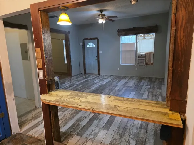 a view of a livingroom with wooden floor and a ceiling fan