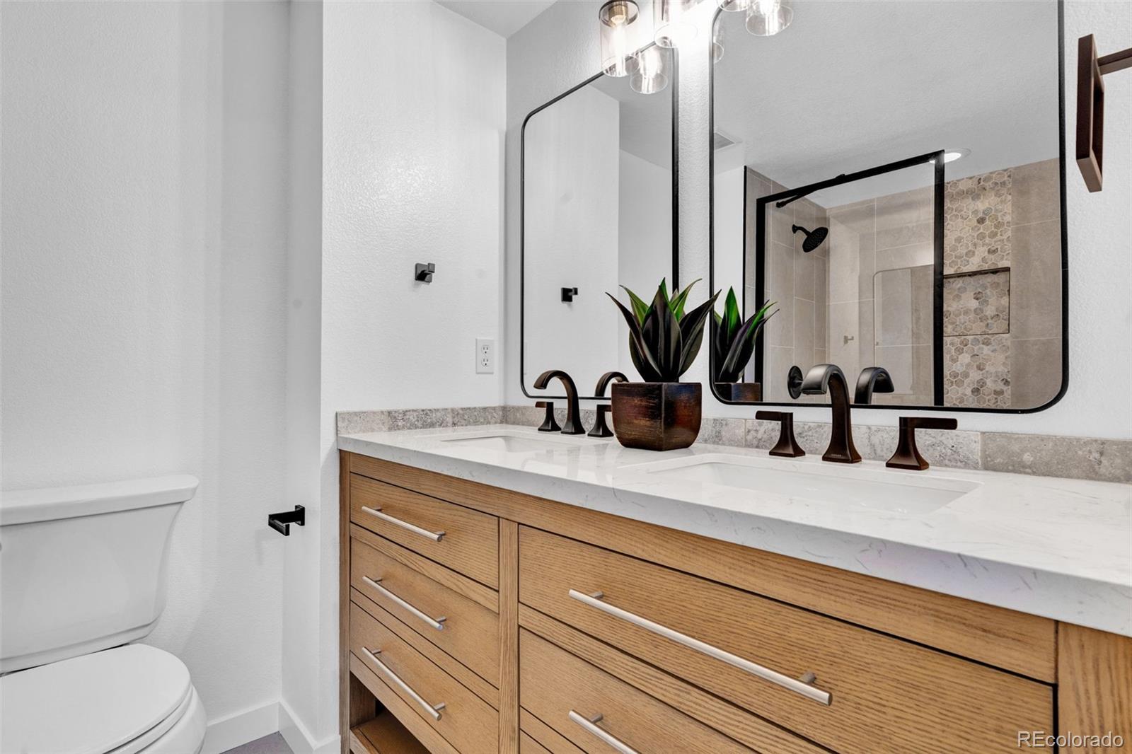 5051 Garrison Street, Unit 7C Wheat Ridge, CO 80033 - Photo 13 of 27 a bathroom with a sink a toilet and mirror
