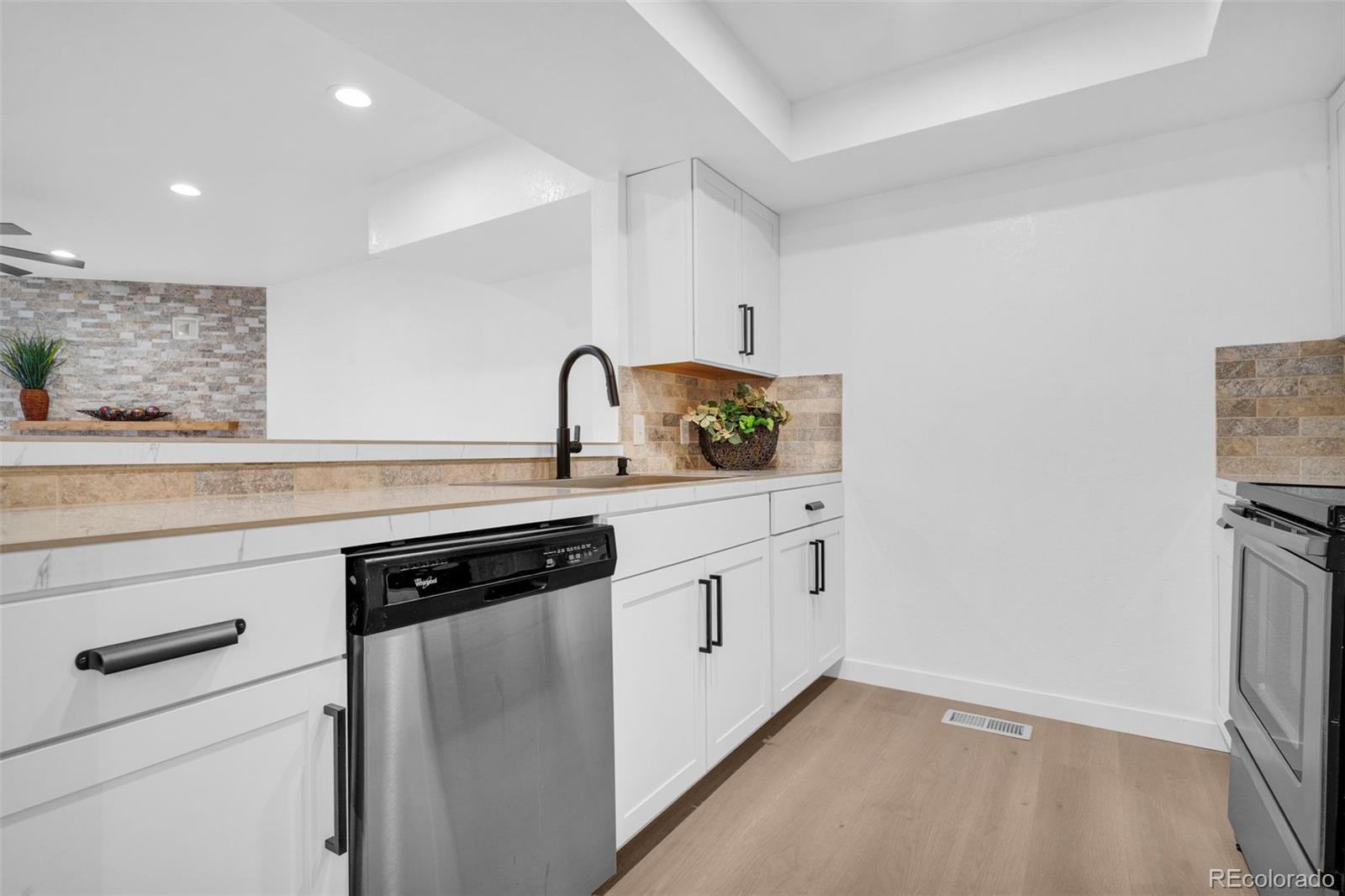 5051 Garrison Street, Unit 7C Wheat Ridge, CO 80033 - Photo 3 of 27 a kitchen with a sink cabinets and appliances