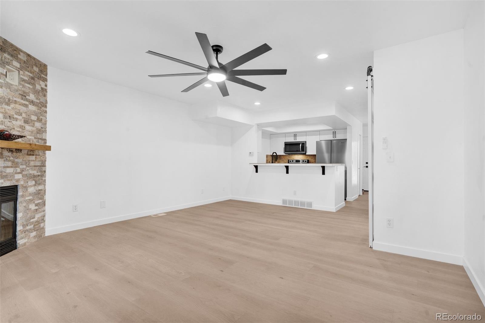 5051 Garrison Street, Unit 7C Wheat Ridge, CO 80033 - Photo 6 of 27 a view of a livingroom with a kitchen and a stove top oven