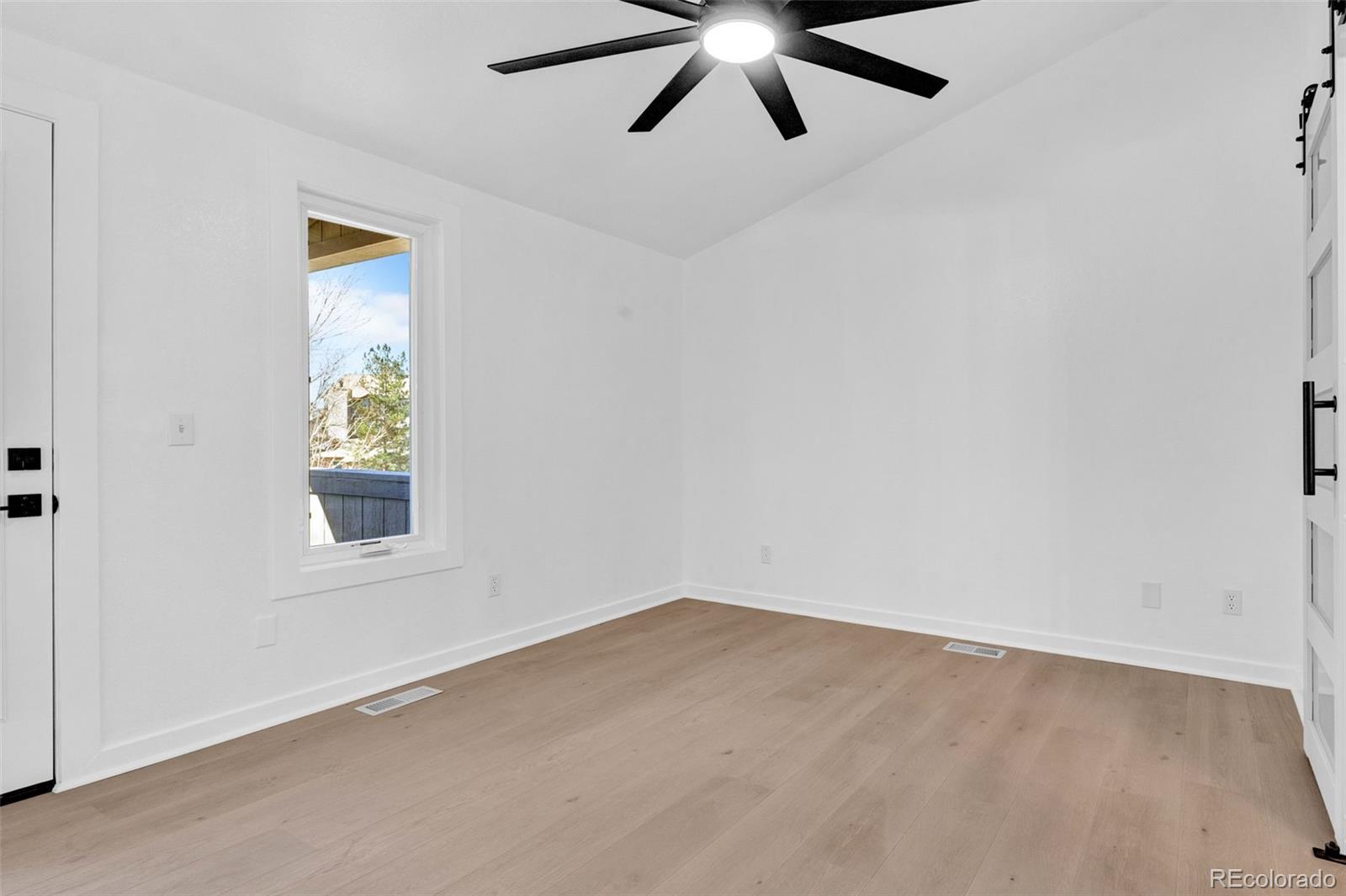 5051 Garrison Street, Unit 7C Wheat Ridge, CO 80033 - Photo 9 of 27 an empty room with a window and a fan