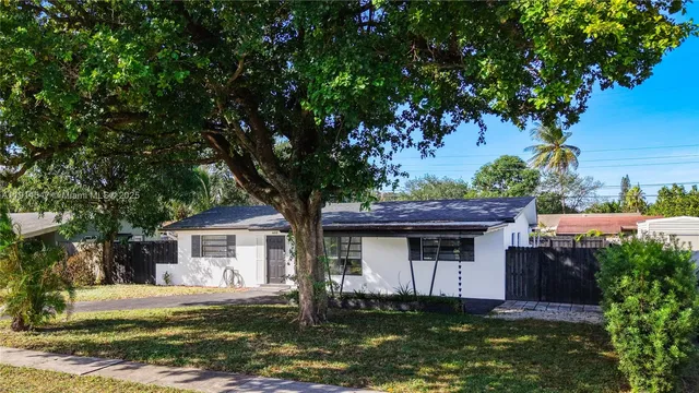 a front view of house with yard garage and tree