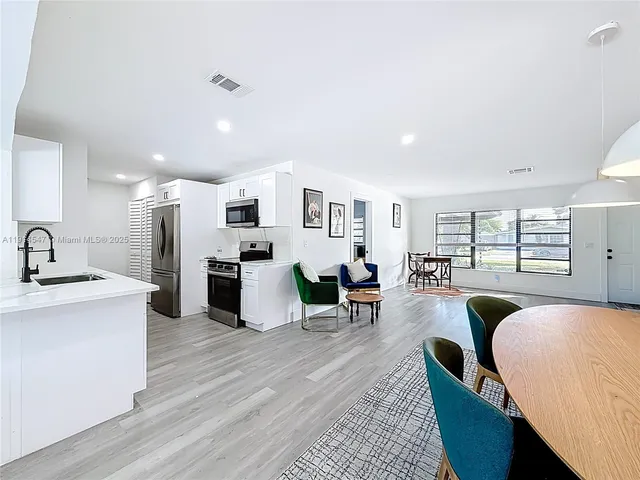a living room with furniture and view of kitchen