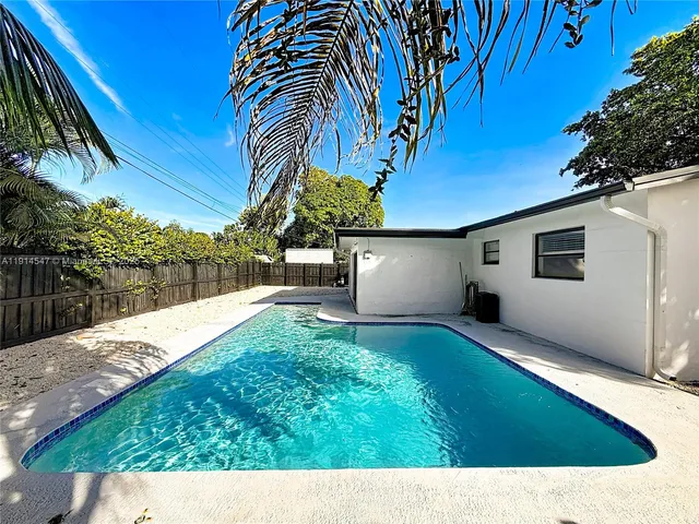 an aerial view of residential houses with outdoor space and swimming pool