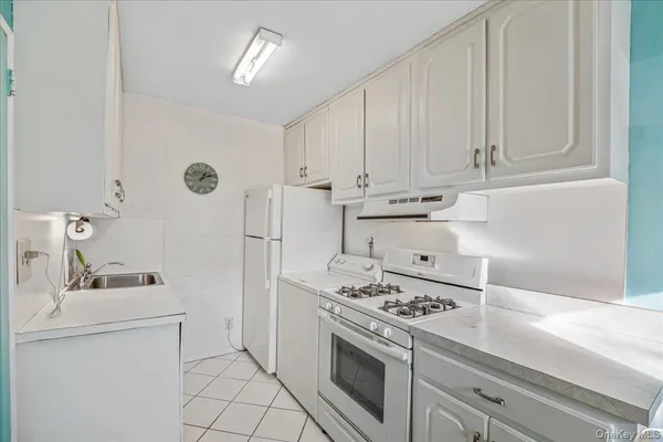 a kitchen with white cabinets and white appliances