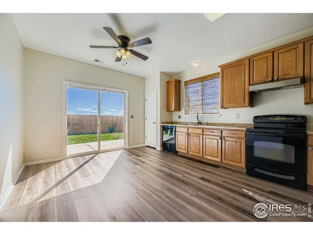 a open kitchen with granite countertop a stove top oven a sink a counter space and cabinets