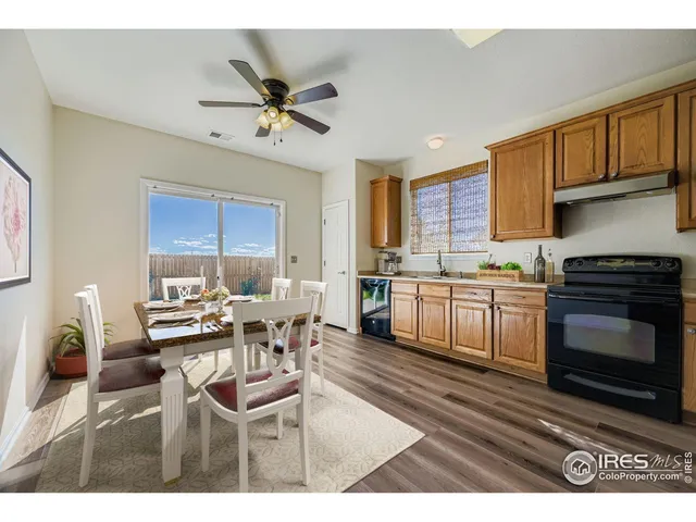 a kitchen with a dining table wooden floor and stainless steel appliances
