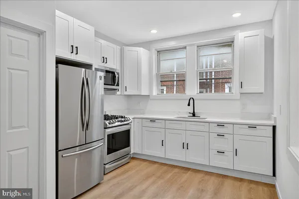 a kitchen with stainless steel appliances granite countertop a refrigerator sink and cabinets