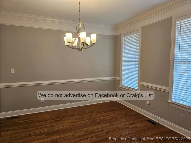 a view of a room with wooden floor and chandelier