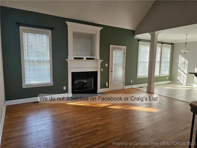 an empty room with wooden floor and a fireplace