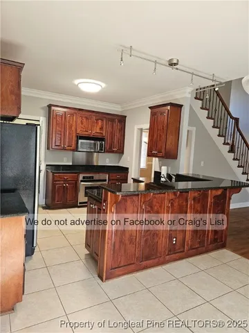 a kitchen with stainless steel appliances kitchen island granite countertop a refrigerator and a stove top oven