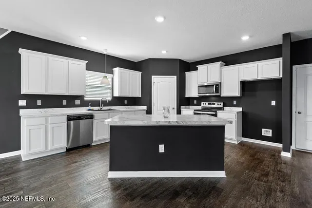 a kitchen with stainless steel appliances granite countertop a stove a sink and a refrigerator