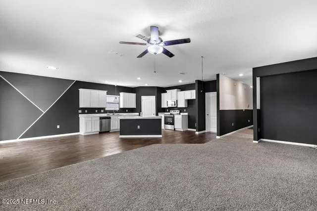 a view of a kitchen with a sink and stainless steel appliances