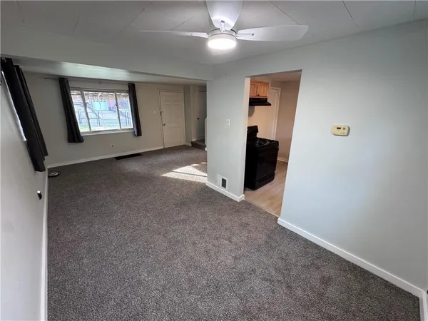 an empty room with windows and cabinet